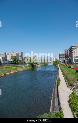 Capturer la beauté sereine de Morioka depuis le pont de Kaiun : une vue imprenable de jour de printemps sur le mont Iwate avec son sommet enneigé, son ciel bleu clair, et t Banque D'Images