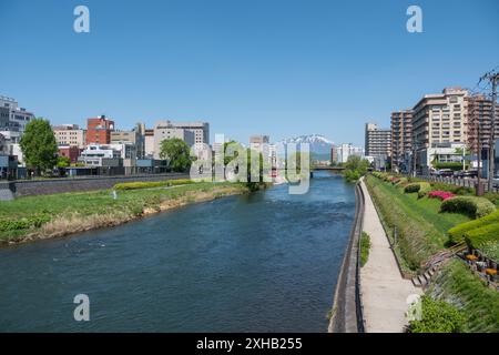 Capturer la beauté sereine de Morioka depuis le pont de Kaiun : une vue imprenable de jour de printemps sur le mont Iwate avec son sommet enneigé, son ciel bleu clair, et t Banque D'Images