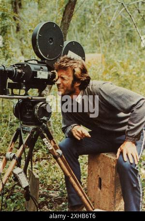 CLINT EASTWOOD sur le lieu de tournage Candid en Louisiane regarde à travers le viseur de la caméra Mitchell pendant le tournage du roman de Thomas Cullinan réalisateur DON SIEGEL DE 1971, Thomas Cullinan directeur de la photographie Bruce Surtees musique Lalo Schifrin The Malpaso Company / Universal Pictures Banque D'Images