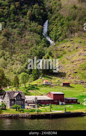 Une vue verticale du hameau de Tufto sur les rives du Naeroyfjord, avec la cascade de Tuftofossen en arrière-plan lors d'une journée ensoleillée en Norvège Banque D'Images