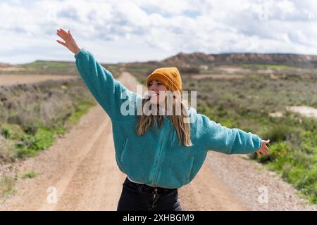 Femme souriante et heureuse à bras ouverts sur la route Banque D'Images