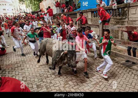 Pampelune, Espagne. 13 juillet 2024. Plusieurs jeunes hommes courent devant un taureau pendant la course des taureaux pendant les festivités de San Fermín 2024. (Photo par Elsa A Bravo/SOPA images/SIPA USA) crédit : SIPA USA/Alamy Live News Banque D'Images