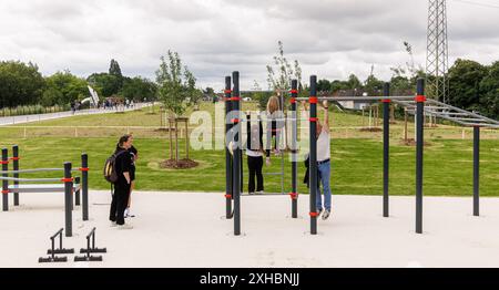 Hambourg, Allemagne. 13 juillet 2024. Les visiteurs font de la gymnastique sur une aire de jeux à l’ouverture du nouveau Deckelpark Stellingen, un parc au-dessus de l’A7. Crédit : Markus Scholz/dpa/Alamy Live News Banque D'Images