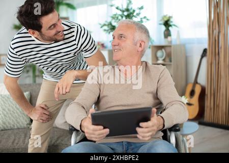 beau fils attentionné avec père âgé handicapé Banque D'Images