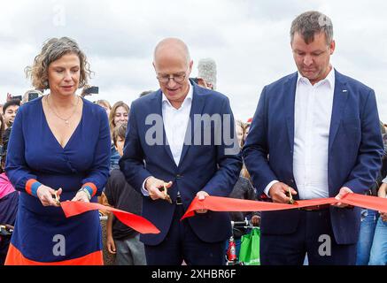 Hambourg, Allemagne. 13 juillet 2024. Sonja Böseler (non-parti, gauche-droite), chef de l'autorité du district de Eimsbüttel, Peter Tschentscher (SPD), premier maire de Hambourg, et Sebastian Haß, chef de projet DEGES, ont coupé un ruban rouge à l'ouverture du nouveau Stellingen Deckelpark, un parc situé au-dessus de l'autoroute A7. Crédit : Markus Scholz/dpa/Alamy Live News Banque D'Images