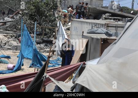 Les Palestiniens fuient après un raid israélien contre les tentes de personnes déplacées dans la zone Al-Mawasi de Khan Yunis dans le sud de la bande de Gaza les Palestiniens fuient après un raid israélien contre les tentes de personnes déplacées dans la zone Al-Mawasi de Khan Yunis dans le sud de la bande de Gaza, 13 juillet 2024. Depuis le 7 octobre 2023, jusqu’à 1,7 millions de personnes, soit plus de 75 % de la population, ont été déplacées dans toute la bande de Gaza, certaines plus d’une fois, en quête de sécurité, selon l’Office de secours et de travaux des Nations Unies pour les réfugiés de Palestine dans le proche-Orient, ce qui a ajouté que le Palestin Banque D'Images