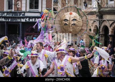 Folkestone, Kent, Royaume-Uni. 13 juillet 2024. Défilé annuel du Charivari Day. Folklore britannique et traditions rituelles sont le thème de la saisissante parade du carnaval de cette année. Des sculptures massives de tête ornent les épaules des jeunes locaux avec des enfants de l'école primaire à travers le district habillant aux couleurs du thème de l'année. Marchant du stade, en passant par la ville jusqu’au kiosque à musique Leas, le Charivari Day reste la plus grande tradition coutumière de Folkestone depuis 1997 et attire des centaines de spectateurs dans la ville portuaire en bord de mer. Crédit : Guy Corbishley/Alamy Live News Banque D'Images