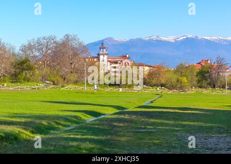 Printemps à Bansko, Bulgarie avec ruisseau d'eau, neige Rila montagnes et maisons Banque D'Images