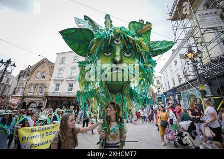 Folkestone, Kent, Royaume-Uni. 13 juillet 2024. Défilé annuel du Charivari Day. Folklore britannique et traditions rituelles sont le thème de la saisissante parade du carnaval de cette année. Des sculptures massives de tête ornent les épaules des jeunes locaux avec des enfants de l'école primaire à travers le district habillant aux couleurs du thème de l'année. Marchant du stade, en passant par la ville jusqu’au kiosque à musique Leas, le Charivari Day reste la plus grande tradition coutumière de Folkestone depuis 1997 et attire des centaines de spectateurs dans la ville portuaire en bord de mer. Crédit : Guy Corbishley/Alamy Live News Banque D'Images