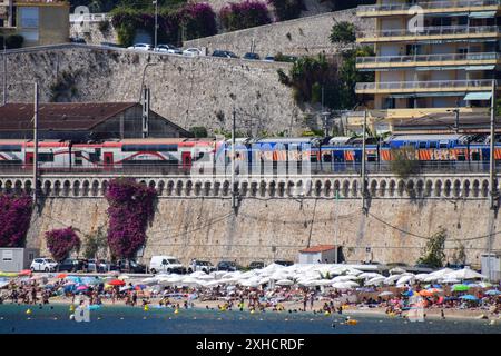 Villefranche-sur-mer, France. 4 août 2019. Un train passe au-dessus d'une plage animée de Villefranche-sur-mer. Crédit : Vuk Valcic/Alamy Banque D'Images