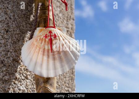 Bâton de marche et de mer du Camino de Santiago penchée sur le mur de pierre de granit. Saint-Jacques-de-Compostelle concept de pèlerinage. Copier l'espace Banque D'Images