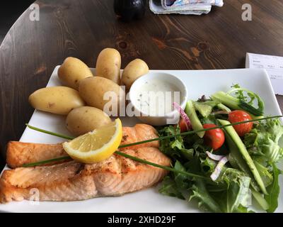 Saumon grillé avec pommes de terre et salade fraîche, servi sur une table en bois dans un style rustique, cuisine norvégienne, Norvège Banque D'Images