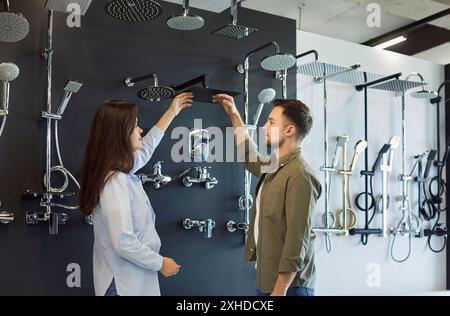 Couple marié sélectionnant robinet de salle de bains dans le magasin de plomberie Banque D'Images