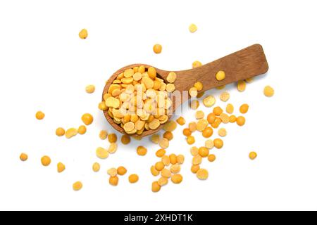 Toor dal ou lentilles jaunes fendues dans une cuillère en bois isolé. Pois chiches fendus dans un sac également connu sous le nom de Chana Dal, Yellow Chana Split Peas. Banque D'Images