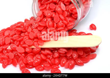 Cirage de granules rouges rose isolé sur fond blanc. Haricots de cire dure dépilatoires. Granules de cire nacrée de rose. Aromathérapie violet rose gouttes de cire fo Banque D'Images