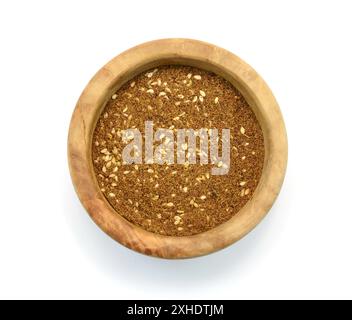 Épice Zaatar dans un bol en bois isolé sur blanc. Pile de zatar (za'atar), un mélange d'épices du moyen-Orient avec des graines de sésame, du sel, de l'origan, du thym.. Banque D'Images