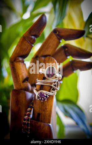 Bagues et autres bijoux disposés sur une main en bois Banque D'Images