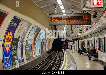 Passagers attendent sur la plate-forme à la station de métro Shepherds Bush pour un train sur la ligne centrale. Banque D'Images