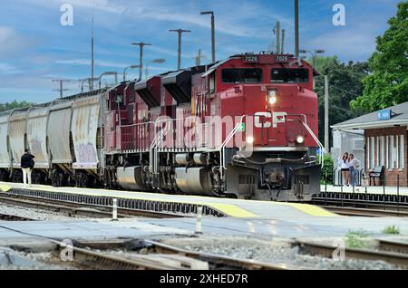 Franklin Park, Illinois, États-Unis. Les locomotives du chemin de fer canadien Pacifique dirigent un train de céréales vers l'est à travers une station de banlieue de Chicago. Banque D'Images