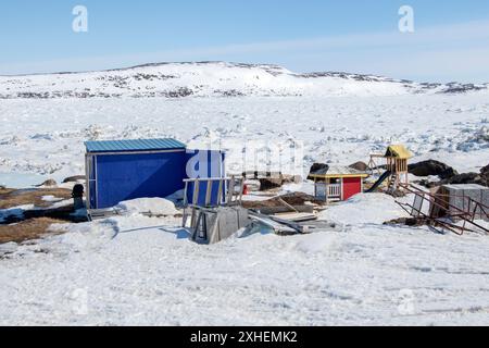 Cabanes et hangars au camp de chasse/pêche sur la plage de Frobisher Bay à Apex, Nunavut, Canada Banque D'Images