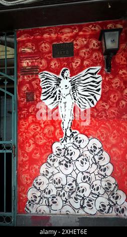 Naples, Italie. 23 juin 2024. Un ange sur une pile de crânes représenté sur un mur dans le centre historique de la ville. Banque D'Images