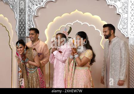 Mumbai, Inde. 12 juillet 2024. G-d Akash Ambani (fils de l'homme d'affaires indien Mukesh Ambani), Shloka Mehta (qui s'incline), l'homme d'affaires indien Mukesh Ambani, Isha Ambani (fille de l'homme d'affaires indien Mukesh Ambani) et Anand Piramal (directeur exécutif du groupe Piramal) saluez les médias alors qu'ils posent pour une photo sur la cérémonie de mariage tapis rouge d'Anant Ambani et Radhika Merchant à Mumbai. Crédit : SOPA images Limited/Alamy Live News Banque D'Images