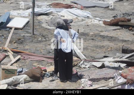 Vue sur les destructions suite à une attaque israélienne le 13 juillet 2024 à Khan Younis, dans la bande de Gaza. Une frappe aérienne israélienne a tué au moins 90 Palestiniens dans une zone humanitaire désignée à Gaza samedi, a déclaré le ministère de la santé de l'enclave, dans une attaque qui, selon Israël, ciblait le chef militaire du Hamas Mohammed Deif. Le premier ministre israélien Benjamin Netanyahu a déclaré qu’il n’était toujours pas clair si Deif et un autre commandant du Hamas avaient été tués et a promis de continuer à cibler les dirigeants du Hamas, affirmant que plus de pression militaire sur le groupe améliorerait les chances d’un accord d’otages, même trois jours de ceas Banque D'Images