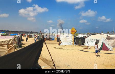 Montée de fumée suite à une attaque israélienne le 13 juillet 2024 à Khan Younis, dans la bande de Gaza. Une frappe aérienne israélienne a tué au moins 90 Palestiniens dans une zone humanitaire désignée à Gaza samedi, a déclaré le ministère de la santé de l'enclave, dans une attaque qui, selon Israël, ciblait le chef militaire du Hamas Mohammed Deif. Le premier ministre israélien Benjamin Netanyahu a déclaré qu’il n’était toujours pas clair si Deif et un autre commandant du Hamas avaient été tués et a promis de continuer à cibler les dirigeants du Hamas, affirmant que plus de pression militaire sur le groupe améliorerait les chances d’un accord d’otages, même après trois jours de pourparlers de cessez-le-feu Banque D'Images