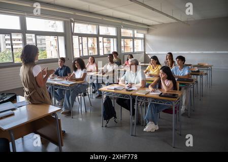 Enseignante dans une classe avec un groupe d'adolescents, étudiants multiethniques. Lycée, université Banque D'Images