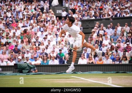 LONDRES, ANGLETERRE - 14 JUILLET : Carlos Alcaraz d'Espagne sert contre Novak Djokovic de Serbie dans la finale des Gentlemen's Singles lors de la quatorzième journée des Championnats de Wimbledon 2024 au All England Lawn Tennis and Croquet Club le 14 juillet 2024 à Londres, Angleterre. Crédit : MB Media solutions/Alamy Live News Banque D'Images