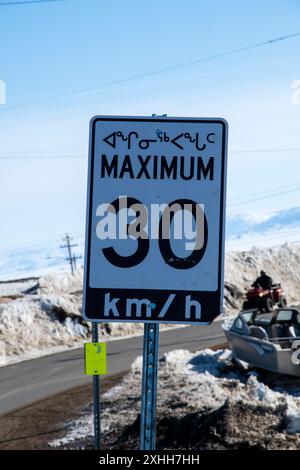 Panneau bilingue de limitation de vitesse en anglais et en inuktitut à Iqaluit, Nunavut, Canada Banque D'Images