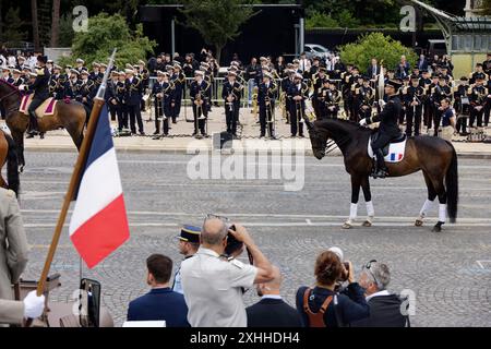 Paris, France. 14 juillet 2024. La torche olympique portée à cheval par le colonel Thibaut Vallette, écuyer en chef du cadre Noir de Saumur et médaillé d’or par équipe aux Jeux Olympiques de Rio de Janeiro en 2016. La flamme olympique est arrivée à Paris le 14 juillet pour être intégrée aux célébrations de la Bastille Day. Célébration du jour de la Bastille, la fête nationale française le dimanche 14 juillet 2024 avec le défilé militaire de l'avenue Foch, en présence du président français Emmanuel Macron à Paris, France. Crédit : Bernard Menigault/Alamy Live News Banque D'Images