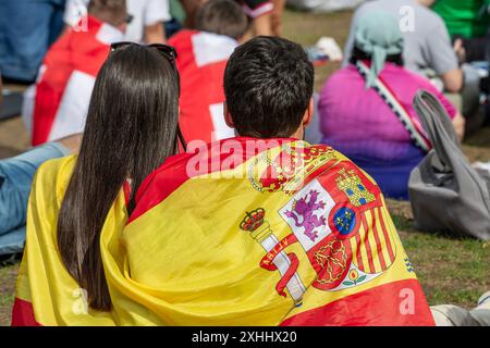 Gemeinsam freuen sich spanische, englische und deutsche fans auf das EM-Endspiel Spanien gegen England, public Viewing in der Fan zone, München, 14. Juillet 2024 Deutschland, München, 14. Juli 2024, spanische, englische und deutsche Fußballfans freuen sich gemeinsam auf das EM-finale, sitzen Seite an Seite in der Fan zone des Olympiaparks, warten auf das Endspiel Spanien gegen England, Sommerwetter, fans eingehüllt in spanische und englische Fahnen, public Viewing, Fan zone fast voll, Fußball-EM, UEFA EURO 2024, Fußball-Europameisterschaft, Fußball, sport, *** Espagnol, Anglais et Allemands Loo Banque D'Images