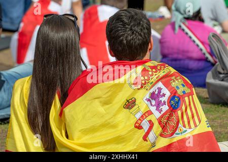 Gemeinsam freuen sich spanische, englische und deutsche fans auf das EM-Endspiel Spanien gegen England, public Viewing in der Fan zone, München, 14. Juillet 2024 Deutschland, München, 14. Juli 2024, spanische, englische und deutsche Fußballfans freuen sich gemeinsam auf das EM-finale, sitzen Seite an Seite in der Fan zone des Olympiaparks, warten auf das Endspiel Spanien gegen England, Sommerwetter, fans eingehüllt in spanische und englische Fahnen, public Viewing, Fan zone fast voll, Fußball-EM, UEFA EURO 2024, Fußball-Europameisterschaft, Fußball, sport, *** Espagnol, Anglais et Allemands Loo Banque D'Images