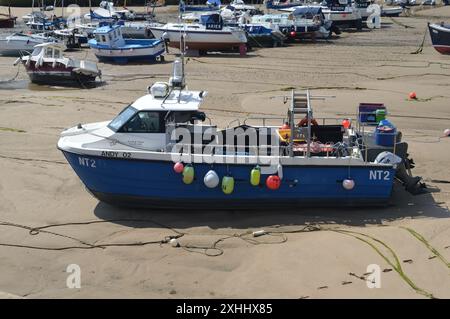 Bateau de pêche échouée dans le port de Tenby à marée basse. Tenby, Pembrokeshire, pays de Galles, Royaume-Uni. 5 juin 2024. Banque D'Images