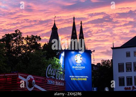 Public Viewing in Köln Fan-zone am Heumarkt Köln 14.07.2024 Blick auf Kölner Dom, Sonnenuntergang, logo von UEFA EURO 2024 auf dem Schild neben Eingang. Visite publique à Köln Fan-zone am Heumarkt Köln 14.07.2024 Köln Heumarkt NRW Deutschland *** visite publique à Cologne Fan-zone à Heumarkt Cologne 14 07 2024 vue de la cathédrale de Cologne, coucher de soleil, logo UEFA EURO 2024 sur le panneau à côté de l'entrée public visionnement dans la zone des fans de Cologne au Heumarkt Cologne 14 07 2024 Cologne Heumarkt NRW Allemagne Copyright : xBEAUTIFULxSPORTS/Buriakovx Banque D'Images