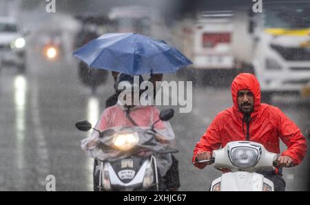 Mumbai, Inde. 14 juillet 2024. MUMBAI, INDE - 14 JUILLET : des gens sous la pluie à Powai, le 14 juillet 2024 à Mumbai, Inde. (Photo de Satish Bate/Hindustan Times/Sipa USA ) crédit : Sipa USA/Alamy Live News Banque D'Images