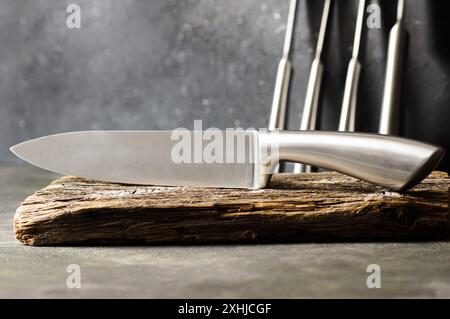 Acier coulant divers couteaux de chef, ensemble de couteaux de cuisine modernes pointus sur fond sombre Banque D'Images