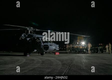 Les marins de l'US Navy affectés au Helicopter Sea combat Squadron (HSC) 21 et au HSC-23, Naval Air Station North Island, San Diego, chargent un système aéroporté de neutralisation des mines sur un MH-60S Seahawk lors de l'exercice Rim of the Pacific 2024, Hawaï, le 12 juillet. Vingt-neuf pays, 40 navires de surface, trois sous-marins, 14 forces terrestres nationales, plus de 150 avions et 25 000 membres du personnel participent au RIMPAC dans et autour des îles Hawaï, du 27 juin au 1er août. Le RIMPAC, le plus grand exercice maritime international au monde, offre une occasion unique de formation tout en favorisant et en soutenant la coopération Banque D'Images