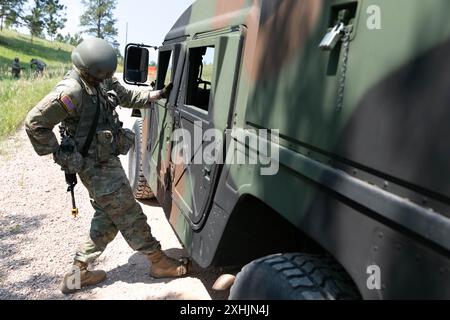 John Gaston, officier candidat de l’armée américaine, classe 24-001, 1-196th Regiment, Regional Training Institute, South Dakota Army National Guard, vérifie la présence d’explosifs potentiels sous un véhicule ennemi dans le cadre d’un exercice de contrôle de la circulation au cours de la phase 2 de la South Dakota Army National Guard’s candidate School, sur Camp Rapid, Rapid City, S.D., 12 juillet, 2024. au cours de la phase 2 de l'OCS, les candidats passent quatre semaines à apprendre les procédures de direction des troupes, à émettre des ordres d'opération au niveau de l'escouade, à diriger des missions au niveau de l'escouade et à exécuter des exercices de combat d'infanterie fondamentaux. (Photo de la Garde nationale de l'armée américaine Banque D'Images