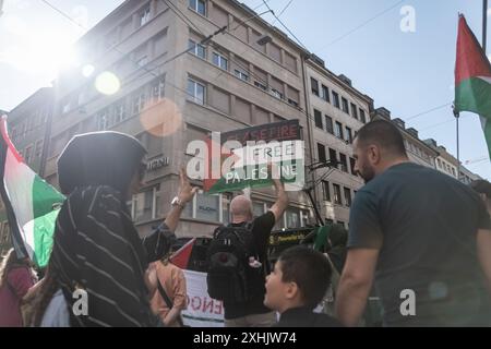Bâle, Suisse. 13 juillet 2024. Un partisan palestinien tient une pancarte pendant le rassemblement. Des dizaines de personnes ont défilé dans les rues de Bâle pour une manifestation spontanée et non autorisée en faveur de la Palestine. Brandissant des drapeaux et chantant des slogans célèbres comme « de la rivière à la mer », la procession a commencé à BarfÃ¼serplatz et a fait une tournée d'une heure et demie à travers la ville. (Crédit image : © Matteo Placucci/SOPA images via ZUMA Press Wire) USAGE ÉDITORIAL SEULEMENT! Non destiné à UN USAGE commercial ! Banque D'Images