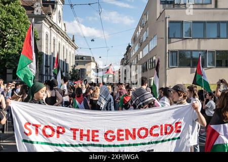 Bâle, Suisse. 13 juillet 2024. Les partisans de la Palestine tiennent une bannière et des drapeaux pendant le rassemblement. Des dizaines de personnes ont défilé dans les rues de Bâle pour une manifestation spontanée et non autorisée en faveur de la Palestine. Brandissant des drapeaux et chantant les fameux slogans comme « de la rivière à la mer », la procession a commencé à Barfüserplatz et a fait une tournée d’une heure et demie à travers la ville. (Photo de Matteo Placucci/SOPA images/SIPA USA) crédit : SIPA USA/Alamy Live News Banque D'Images