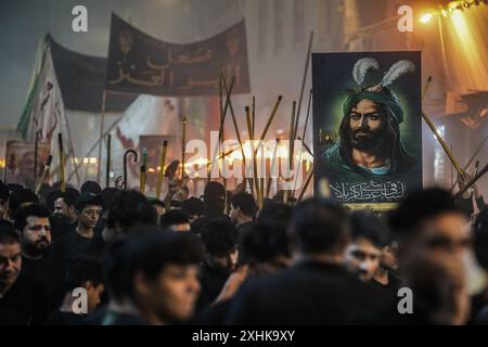 Najaf, Irak. 14 juillet 2024. Les musulmans chiites effectuent des rituels de deuil lors d'une procession religieuse avant le jour de l'Ashura, le dixième jour du mois sacré de Muharram. Ashura commémore le martyre de l'imam Hussein, petit-fils du prophète de l'islam Mohammed, dans la bataille de la ville irakienne de Karbala au VIIe siècle. Crédit : Ismael Adnan/dpa/Alamy Live News Banque D'Images