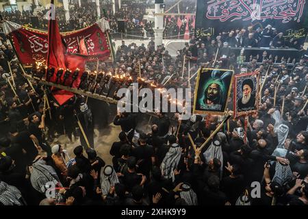 Najaf, Irak. 14 juillet 2024. Les musulmans chiites effectuent des rituels de deuil lors d'une procession religieuse avant le jour de l'Ashura, le dixième jour du mois sacré de Muharram. Ashura commémore le martyre de l'imam Hussein, petit-fils du prophète de l'islam Mohammed, dans la bataille de la ville irakienne de Karbala au VIIe siècle. Crédit : Ismael Adnan/dpa/Alamy Live News Banque D'Images