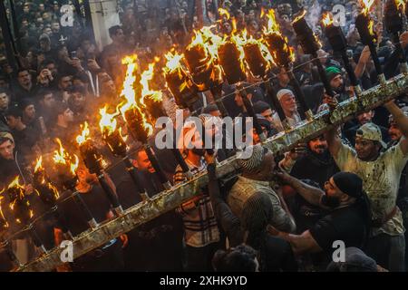 Najaf, Irak. 14 juillet 2024. Les musulmans chiites effectuent des rituels de deuil lors d'une procession religieuse avant le jour de l'Ashura, le dixième jour du mois sacré de Muharram. Ashura commémore le martyre de l'imam Hussein, petit-fils du prophète de l'islam Mohammed, dans la bataille de la ville irakienne de Karbala au VIIe siècle. Crédit : Ismael Adnan/dpa/Alamy Live News Banque D'Images