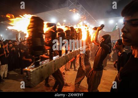 Najaf, Irak. 14 juillet 2024. Les musulmans chiites effectuent des rituels de deuil lors d'une procession religieuse avant le jour de l'Ashura, le dixième jour du mois sacré de Muharram. Ashura commémore le martyre de l'imam Hussein, petit-fils du prophète de l'islam Mohammed, dans la bataille de la ville irakienne de Karbala au VIIe siècle. Crédit : Ismael Adnan/dpa/Alamy Live News Banque D'Images