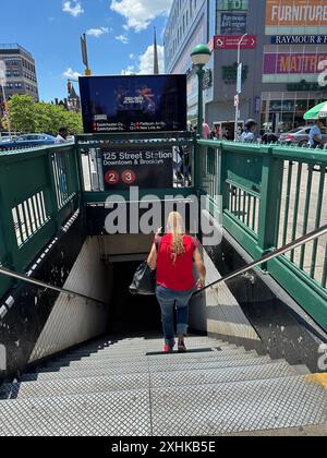 Femme entrant dans la station de métro de la 125e rue du centre-ville dans la section Harlem de Manhattan à New York Banque D'Images