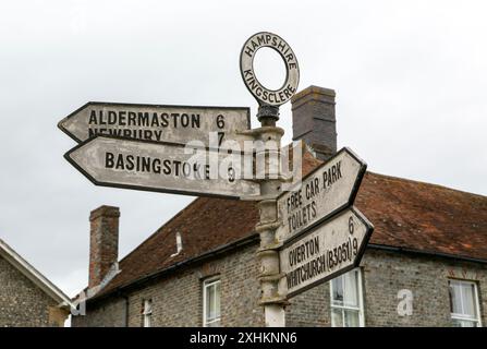 Panneaux de signalisation routière pointeurs de flèche et distances vers les colonies voisines, Kingsclere, Hampshire, Angleterre, Royaume-Uni Banque D'Images