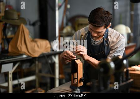 Maroquinier qualifié coudre méticuleusement le cuir pour les produits en cuir dans l'atelier local Banque D'Images