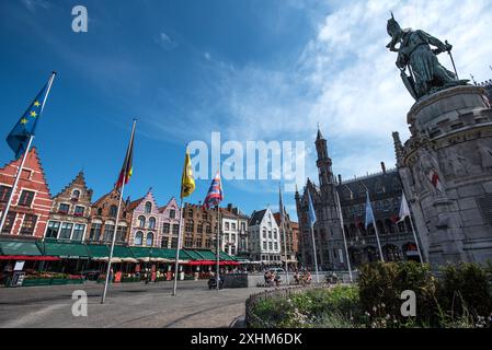 Maisons à pignons colorées et drapeaux dans la vibrante Grote Markt un jour ensoleillé - Bruges, Belgique Banque D'Images